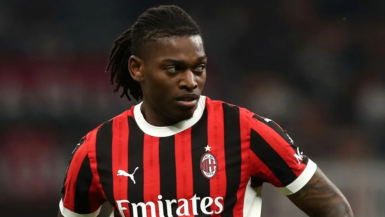 Player in AC Milan jersey on the field Player in AC Milan jersey on the field