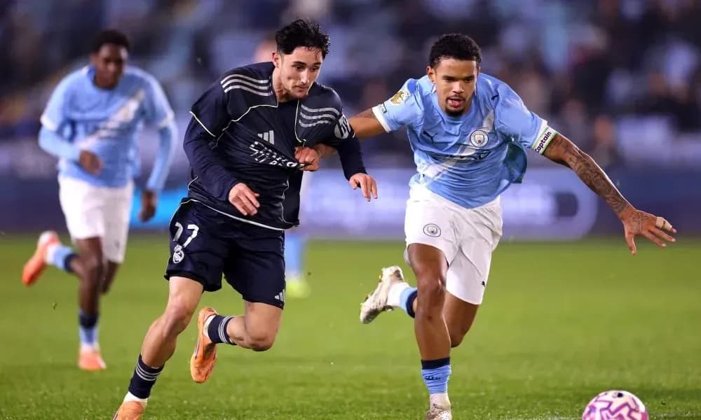 Player from Real Madrid sprinting past Manchester City player Player from Real Madrid sprinting past Manchester City player