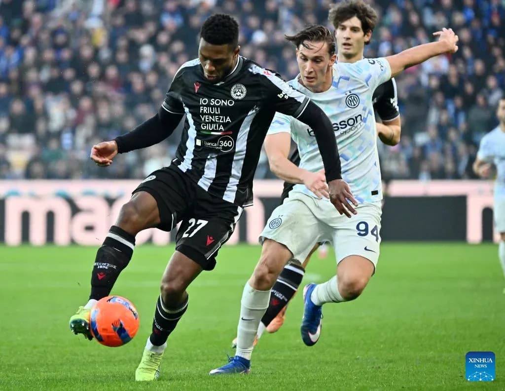 Udinese player challenged by Inter player during match Udinese player challenged by Inter player during match