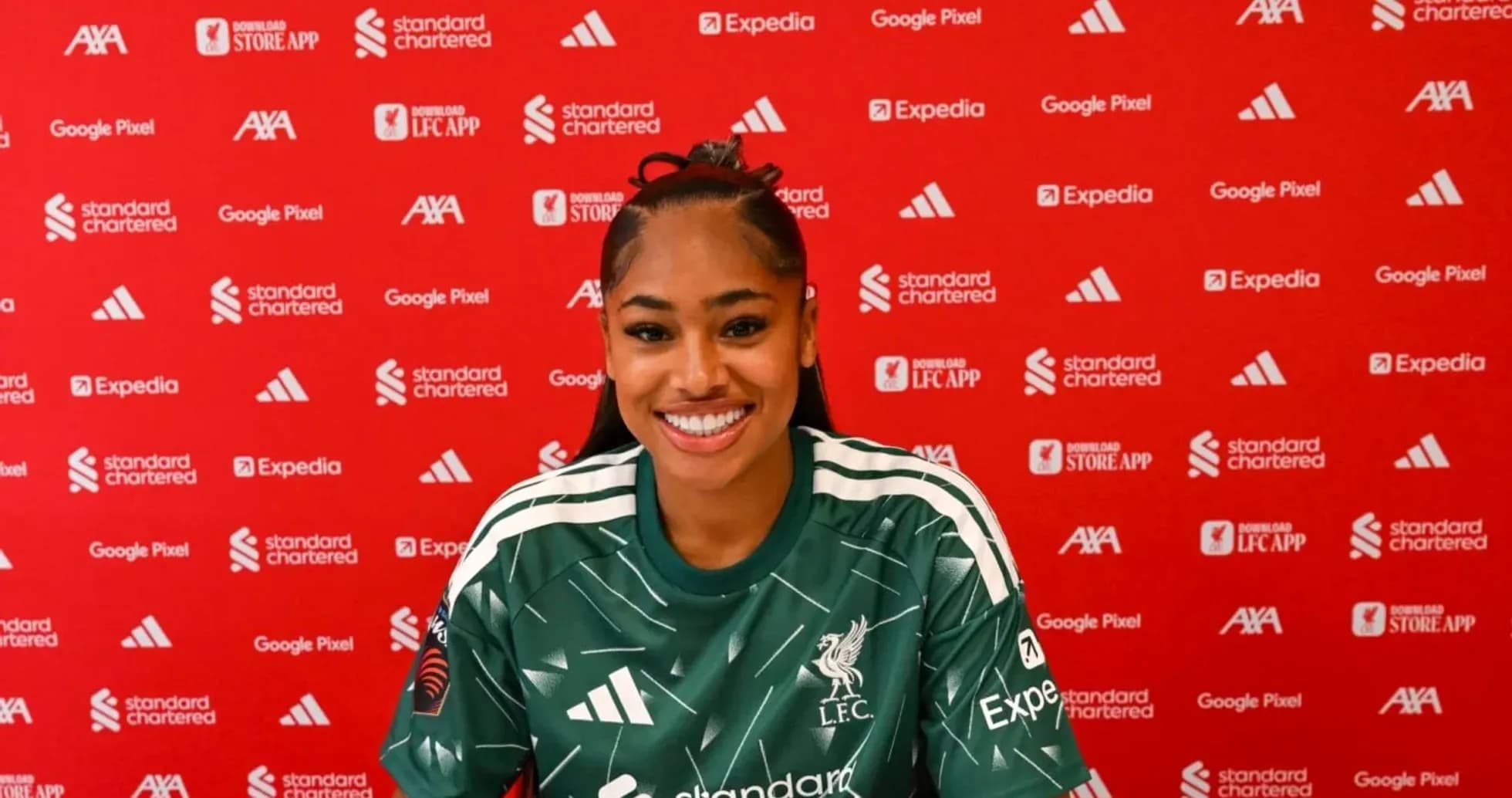 Player smiling at press conference with Liverpool backdrop Player smiling at press conference with Liverpool backdrop