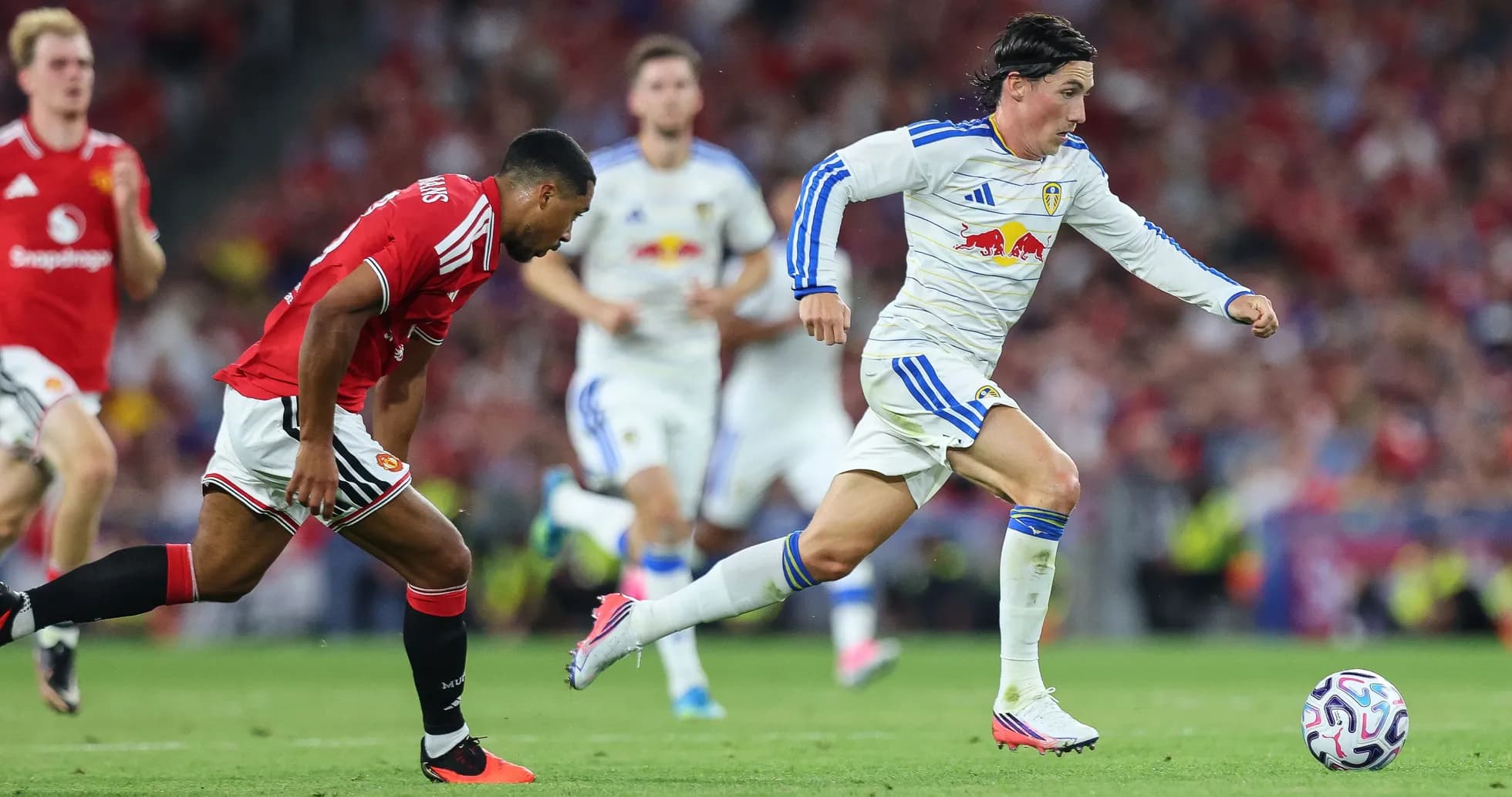 Leeds player sprinting past Manchester United defender Leeds player sprinting past Manchester United defender