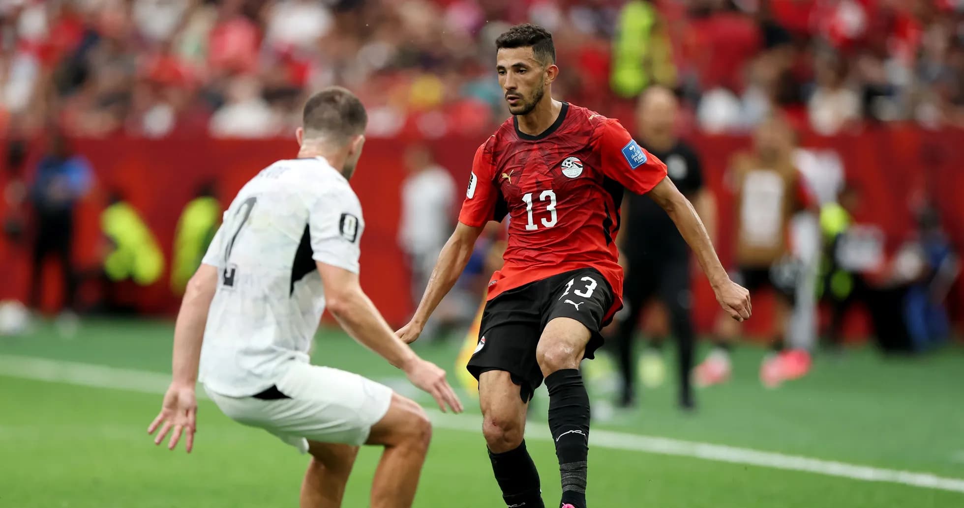 Player in red jersey dribbling past opponent on field Player in red jersey dribbling past opponent on field