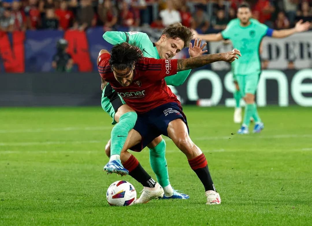 Player tackling opponent during Atletico Madrid match Player tackling opponent during Atletico Madrid match