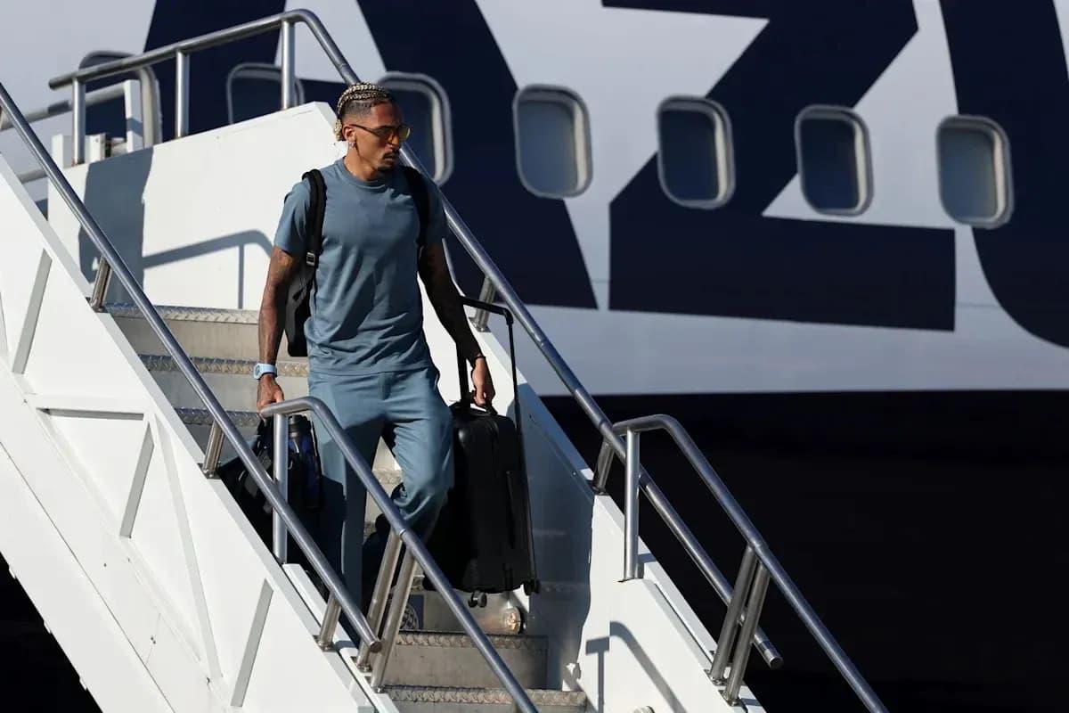 Player descending airplane stairs with luggage Player descending airplane stairs with luggage