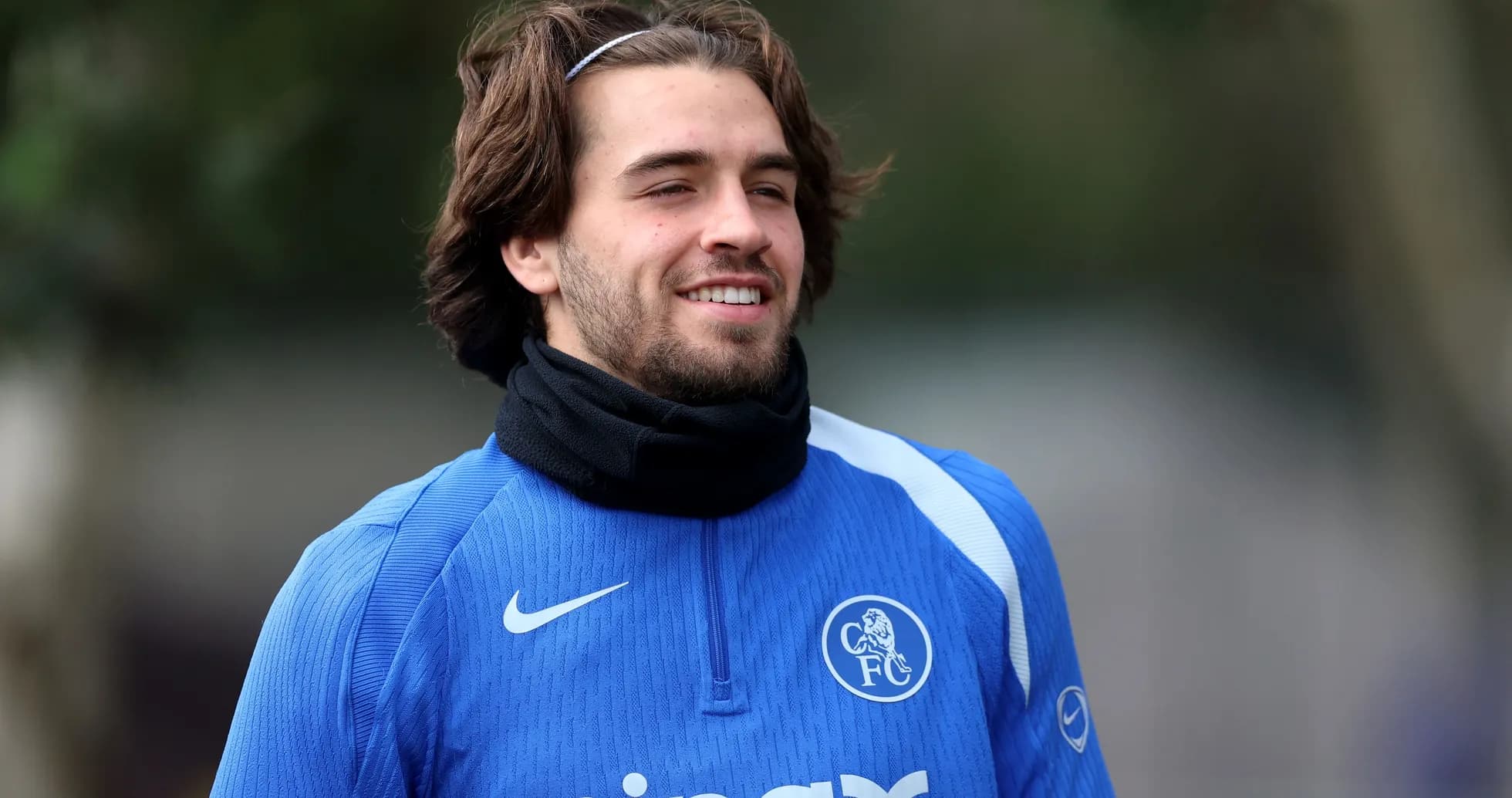 Player in blue training kit smiling outdoors Player in blue training kit smiling outdoors