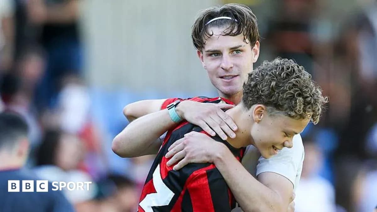 Two football players embracing on the field Two football players embracing on the field
