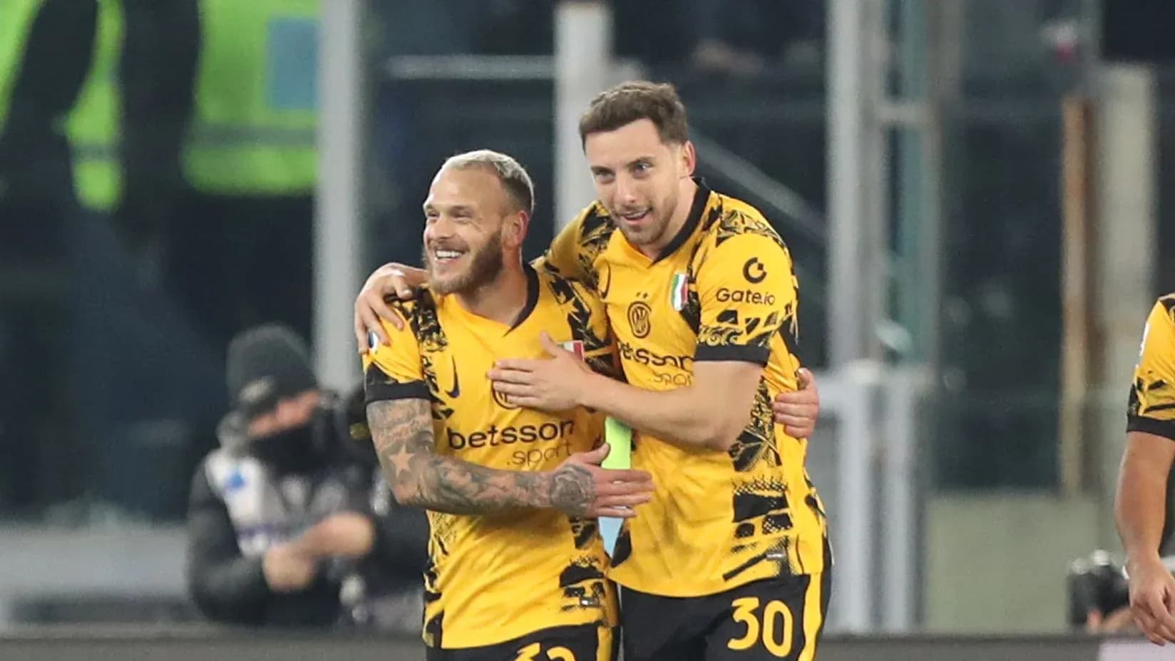 Two players celebrating a goal on the pitch Two players celebrating a goal on the pitch