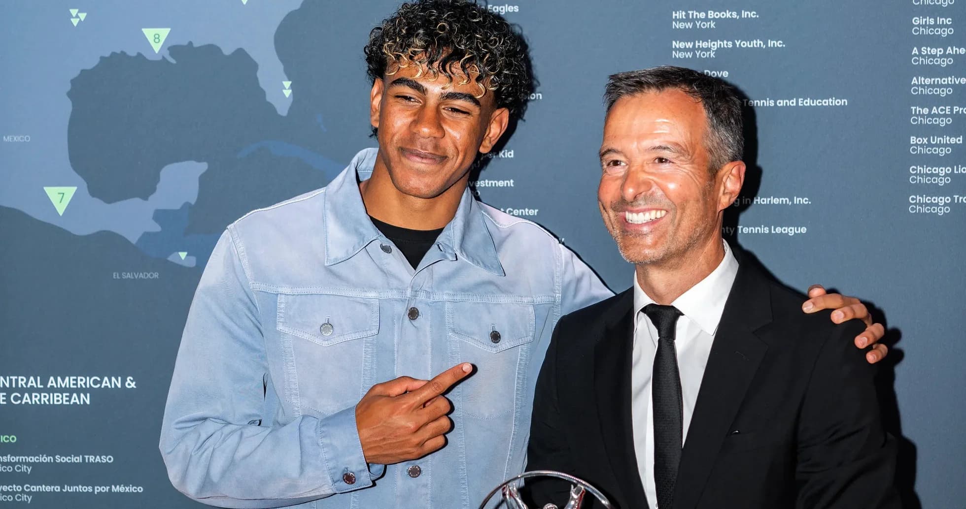 Two men posing with an award at event Two men posing with an award at event