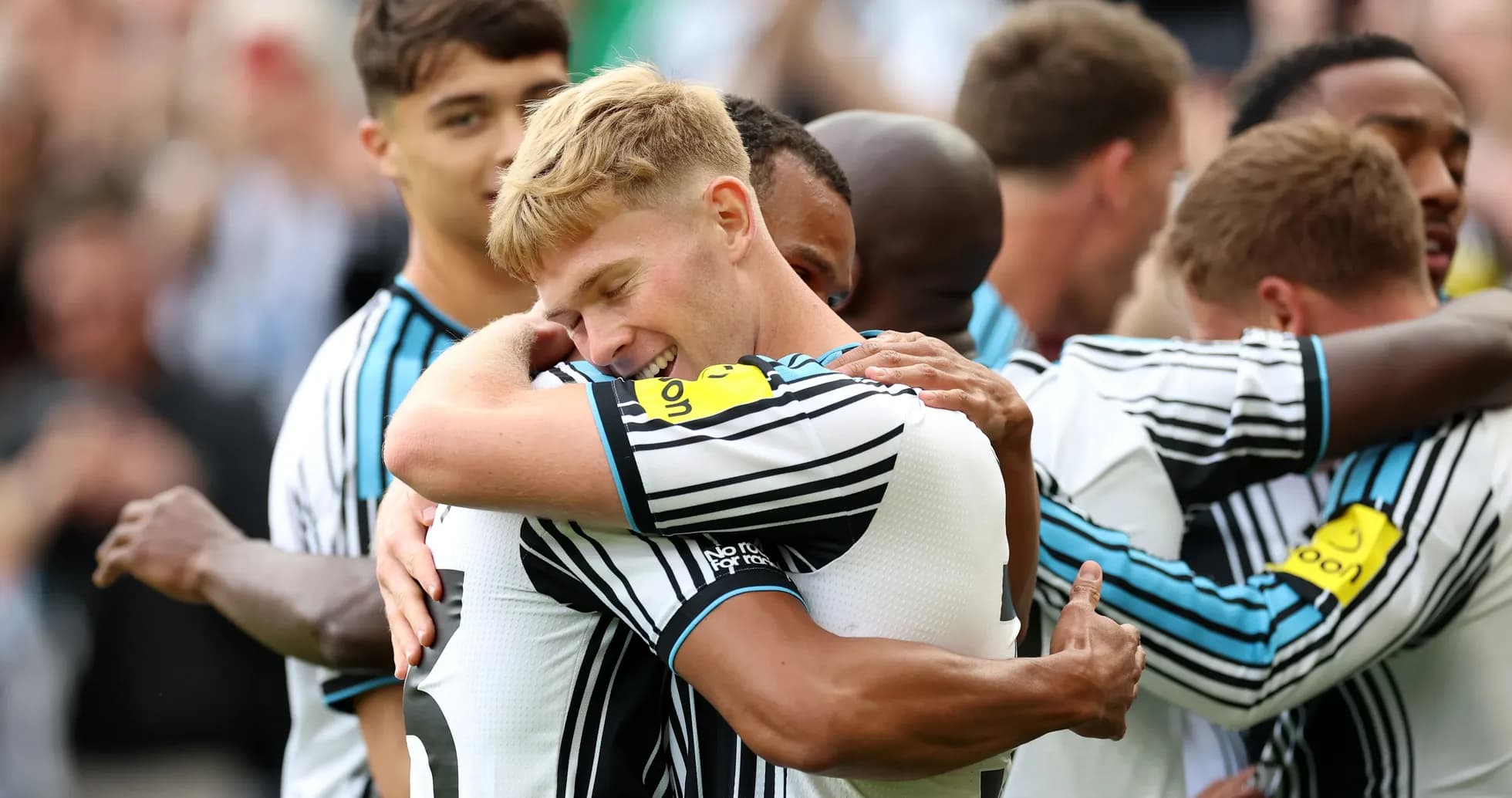 Players celebrating a goal with embraces on field Players celebrating a goal with embraces on field