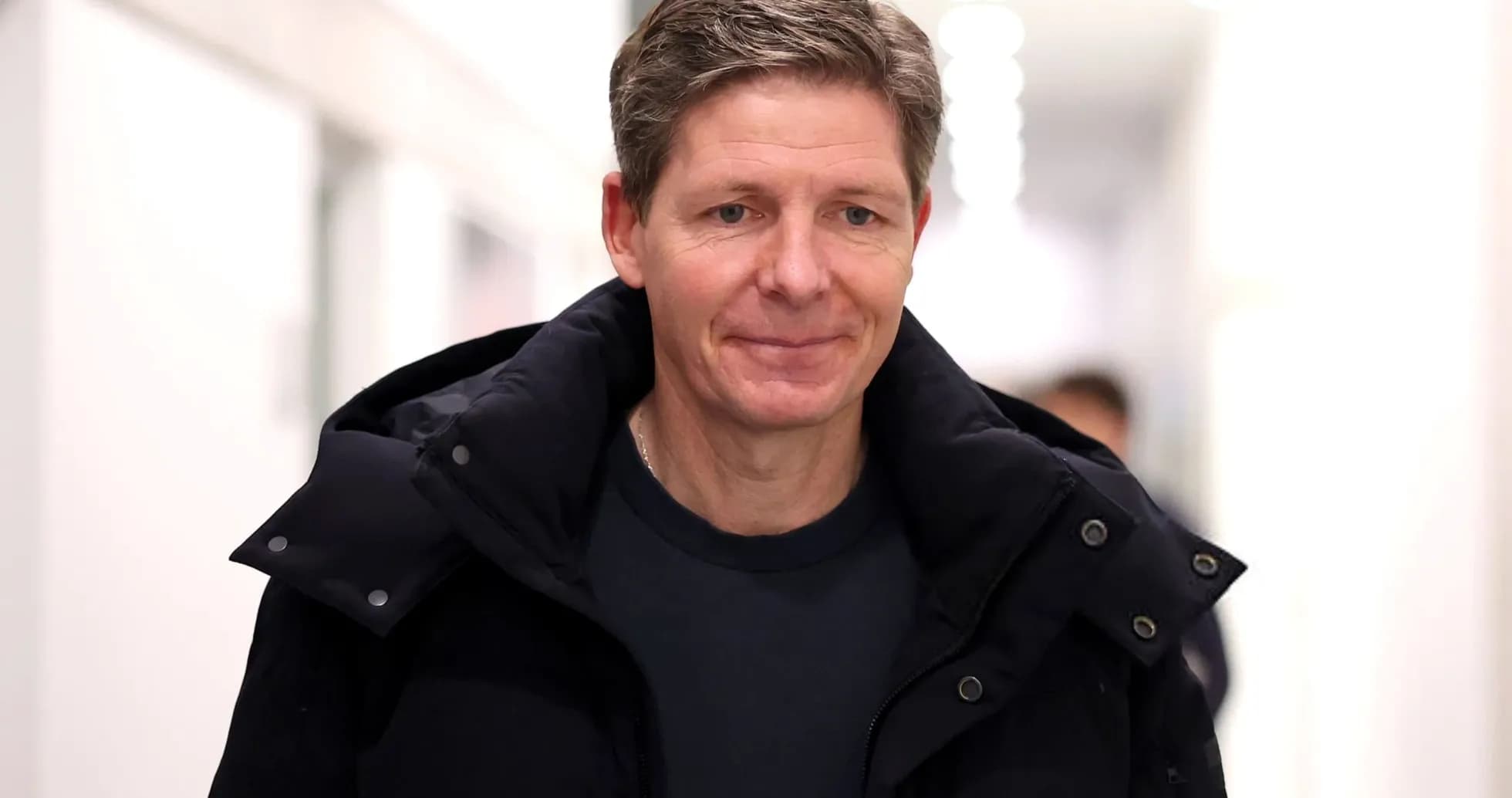 Person walking in a corridor wearing a jacket Person walking in a corridor wearing a jacket