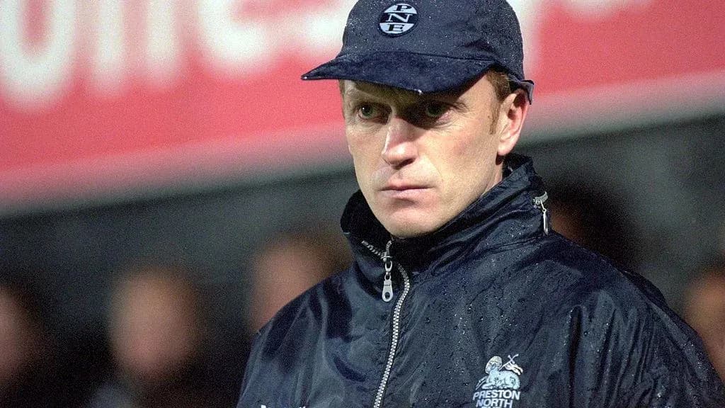 Coach wearing a cap during a rainy match Coach wearing a cap during a rainy match