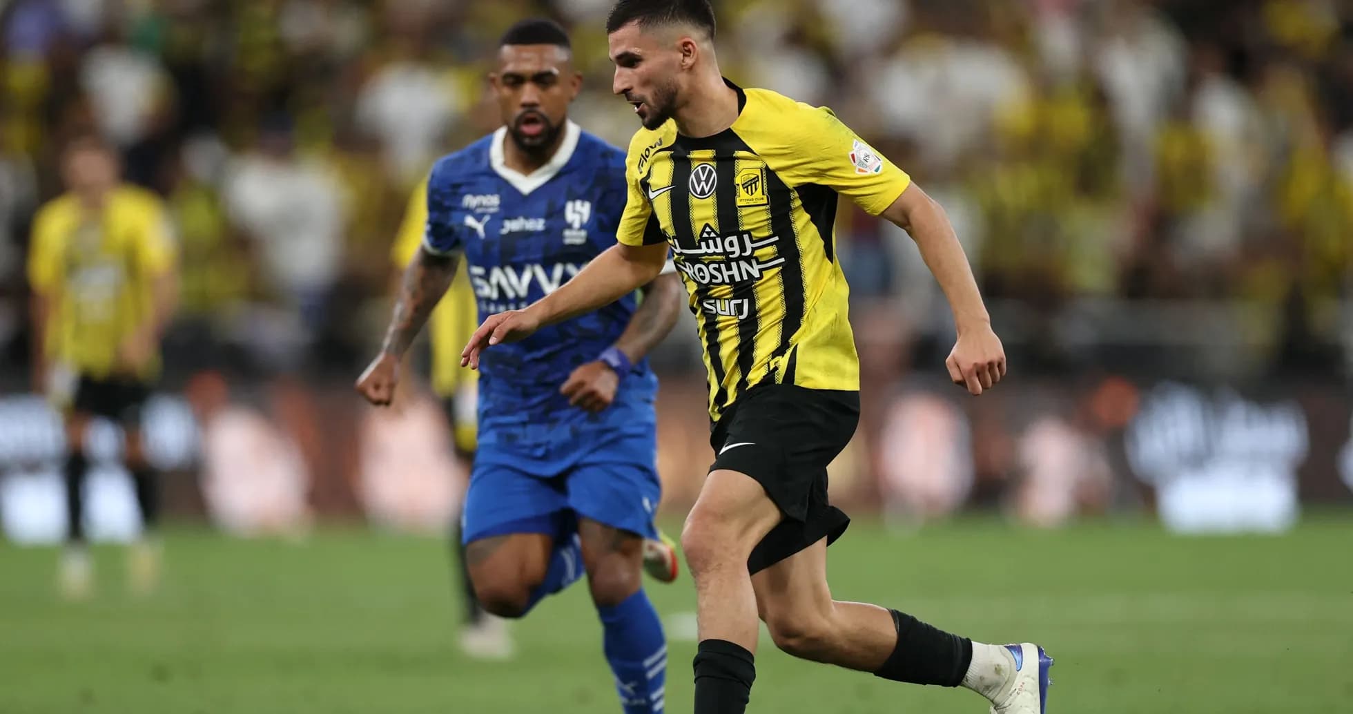 Player in yellow dribbling past opponent in blue Player in yellow dribbling past opponent in blue