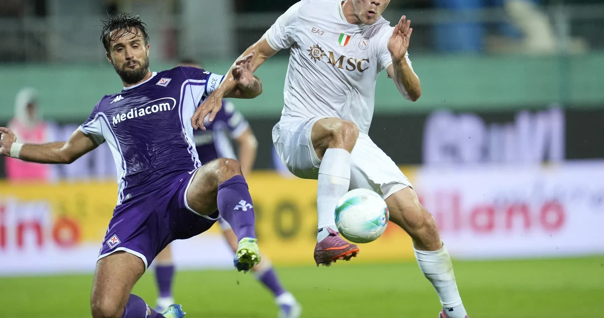 Fiorentina player tackling Napoli opponent during match Fiorentina player tackling Napoli opponent during match