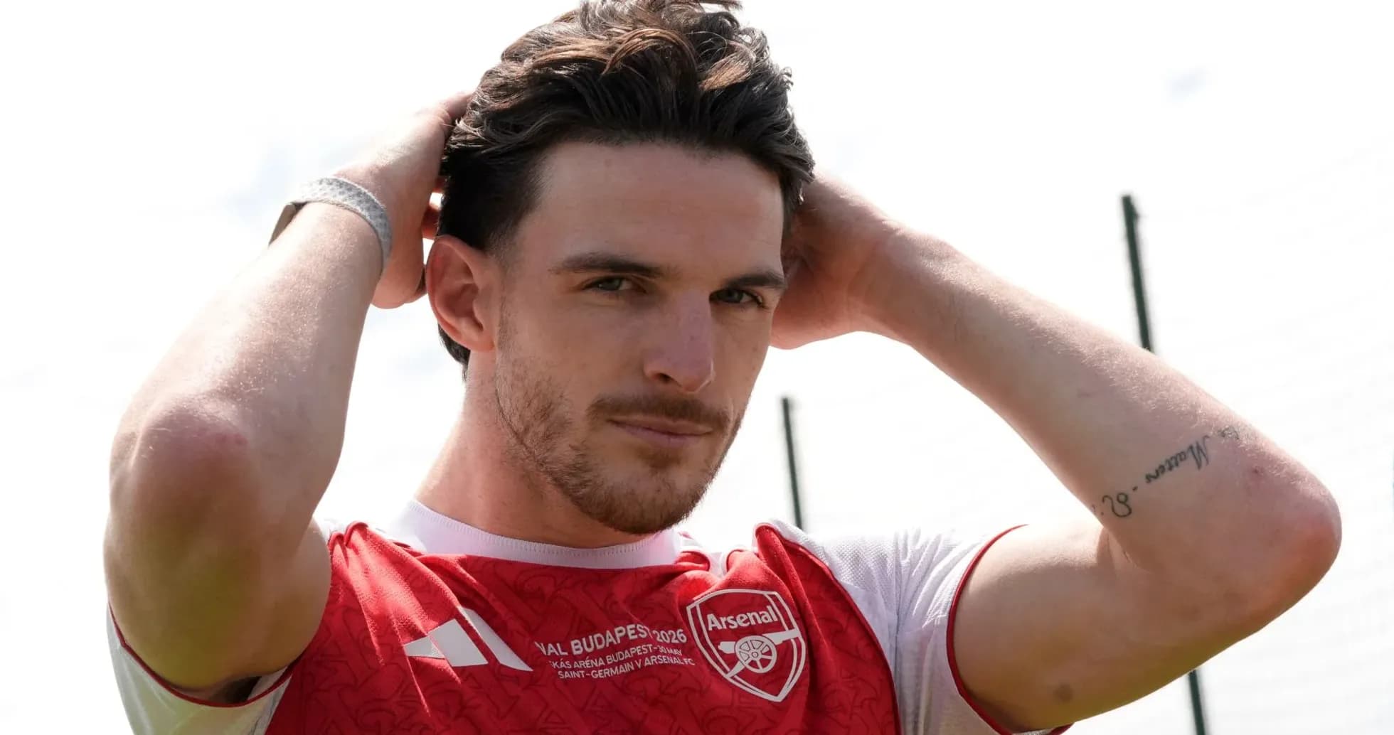 Player adjusting hair while wearing Arsenal jersey Player adjusting hair while wearing Arsenal jersey