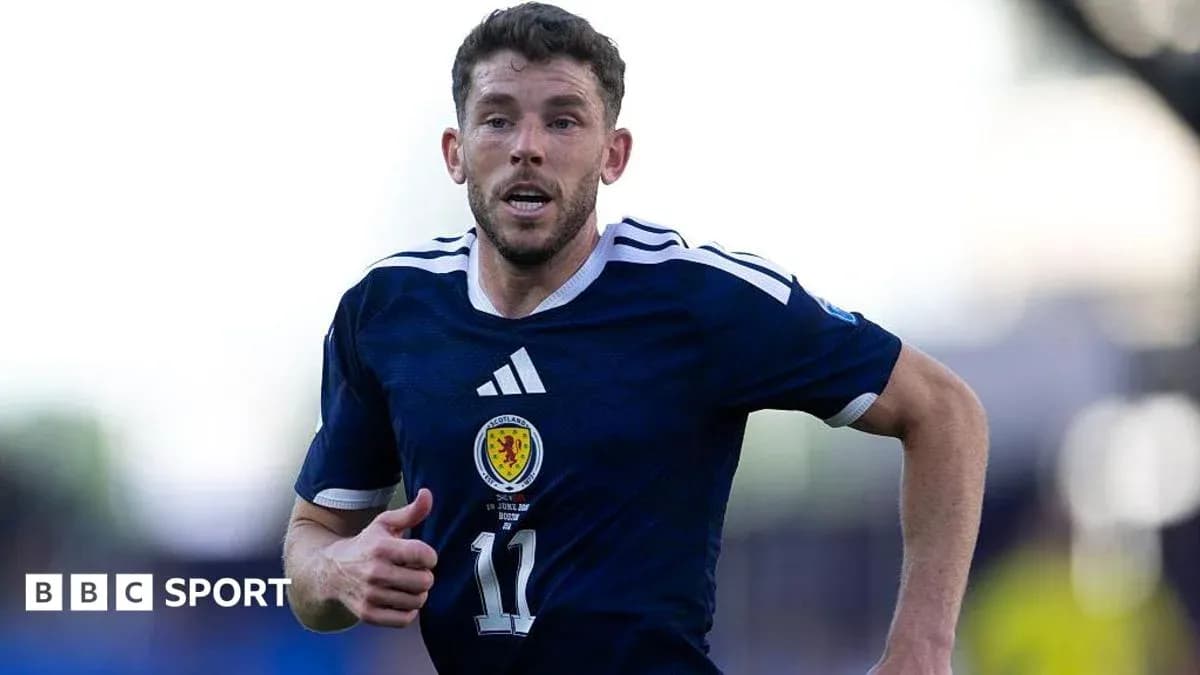 Player running during a football match in Scotland kit Player running during a football match in Scotland kit