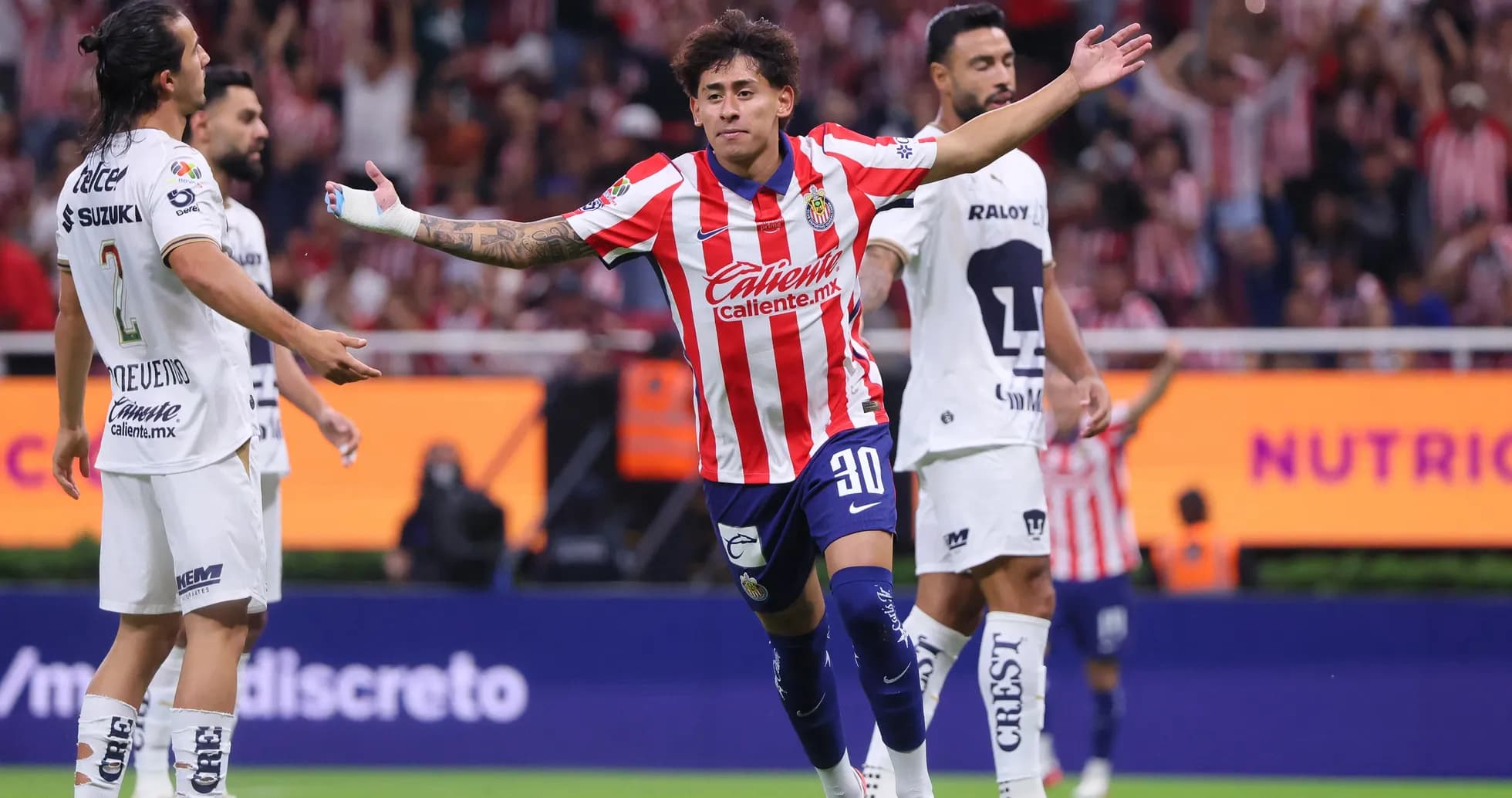 Chivas player celebrating a goal against Pumas Chivas player celebrating a goal against Pumas