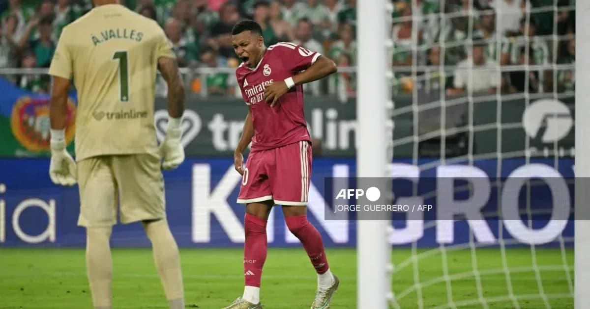 Player reacting during match with goalkeeper in background Player reacting during match with goalkeeper in background