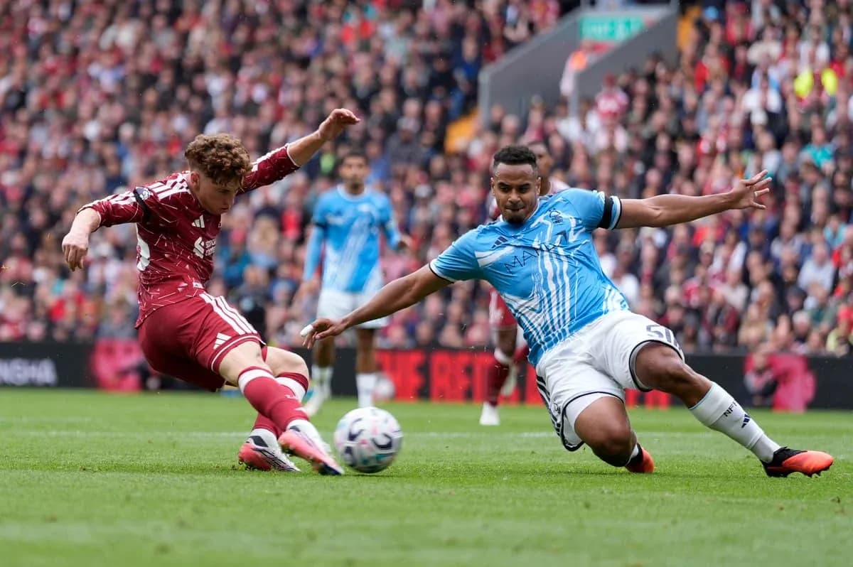 Player in red sliding to tackle opponent in blue Player in red sliding to tackle opponent in blue