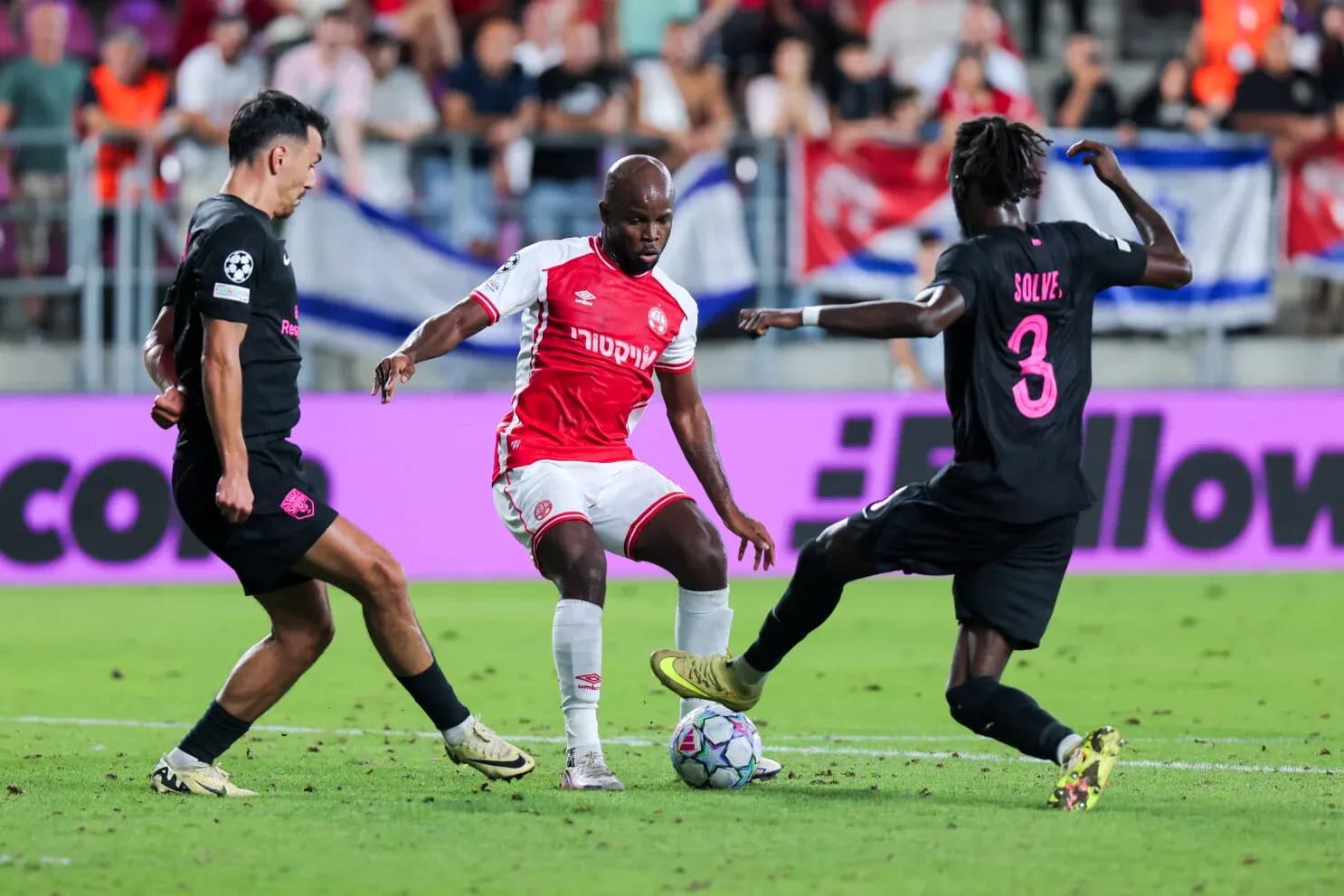 Sabah FA player dribbling past Hapoel defenders Sabah FA player dribbling past Hapoel defenders