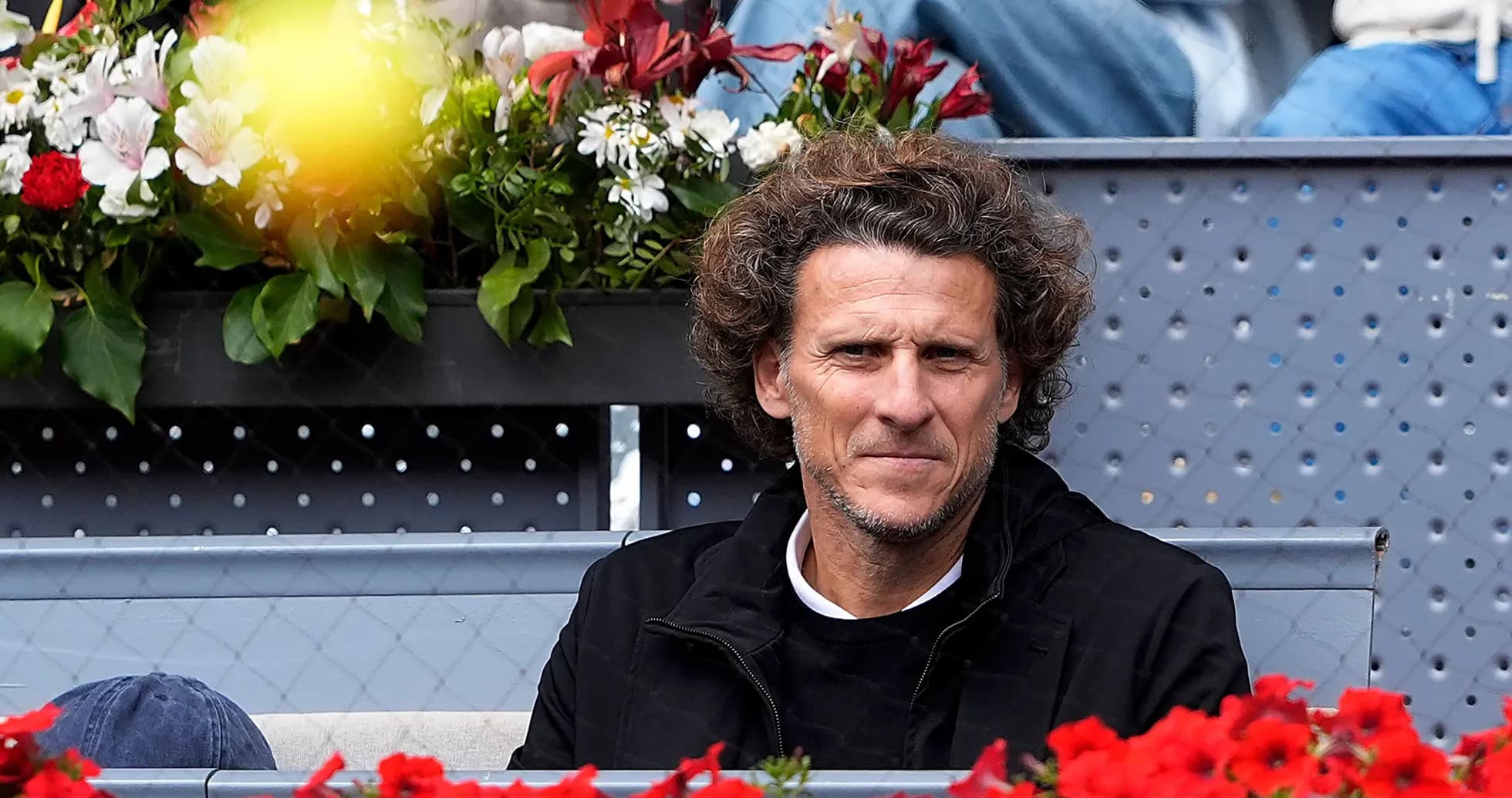 Man sitting among flowers at a tennis event Man sitting among flowers at a tennis event