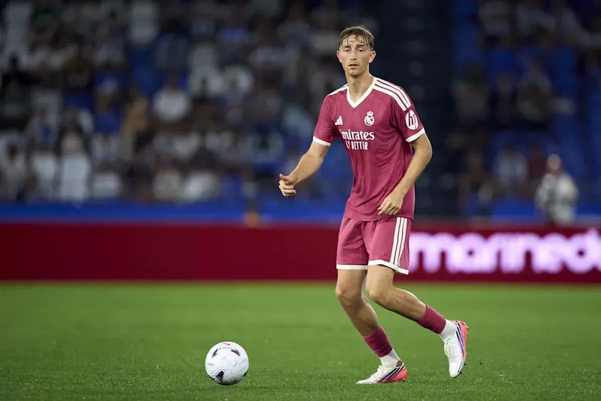 Player in pink kit dribbling ball on field Player in pink kit dribbling ball on field
