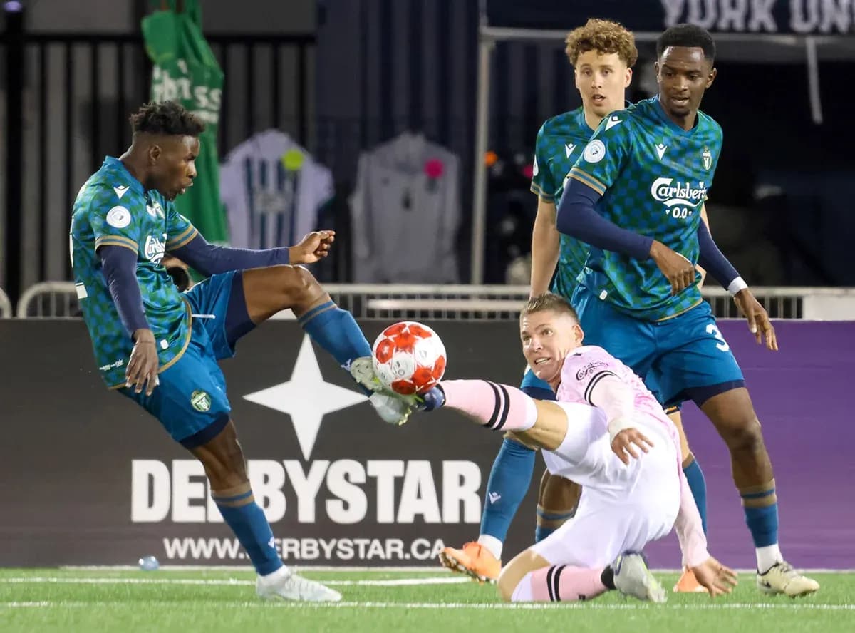 Player tackling goalkeeper during Vancouver FC match Player tackling goalkeeper during Vancouver FC match