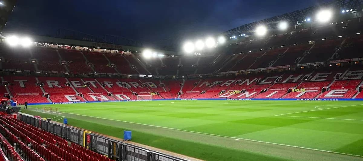 Empty Old Trafford stadium with illuminated stands Empty Old Trafford stadium with illuminated stands