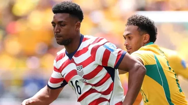 Player in USA jersey evading opponent during match Player in USA jersey evading opponent during match