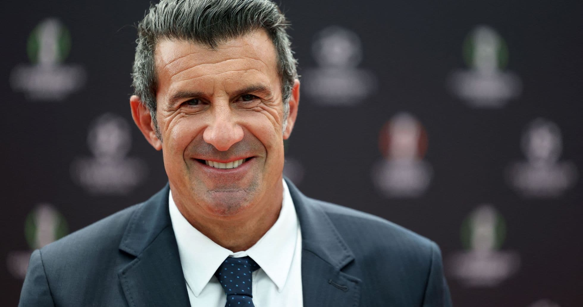 Smiling man in suit at event backdrop Smiling man in suit at event backdrop