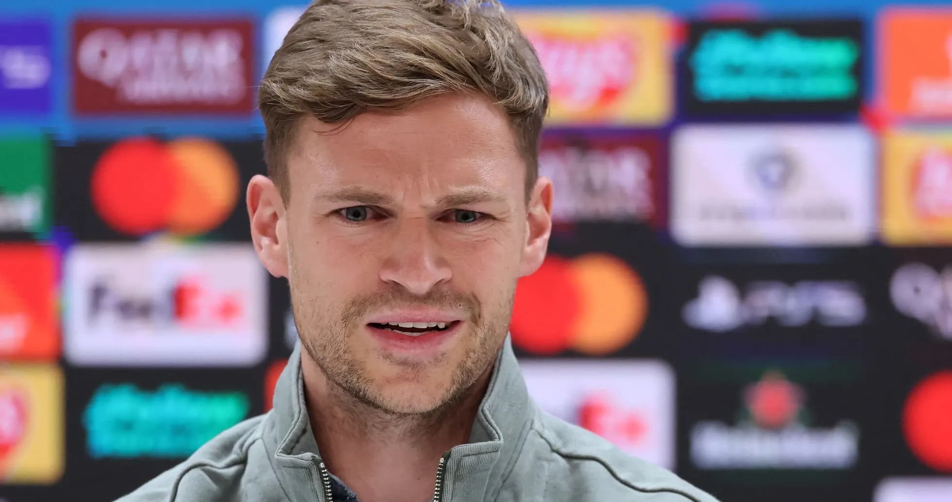 Speaker at press conference with sponsor banners behind Speaker at press conference with sponsor banners behind