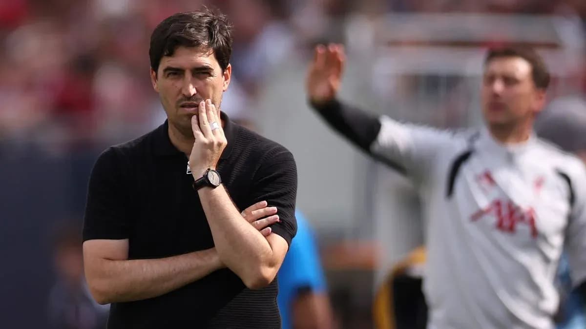 Coach observing match while player gestures behind Coach observing match while player gestures behind