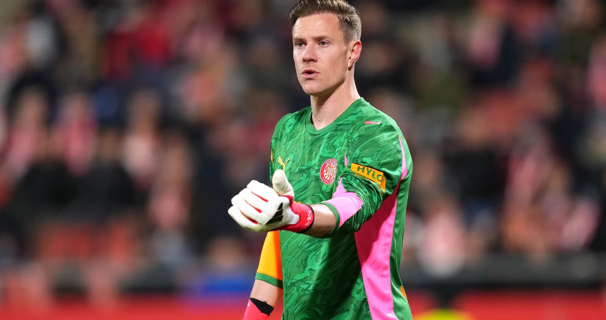 Goalkeeper in green kit signaling during match Goalkeeper in green kit signaling during match