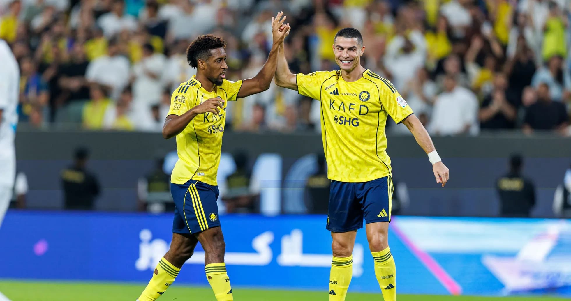 Two players celebrating a goal on the field Two players celebrating a goal on the field