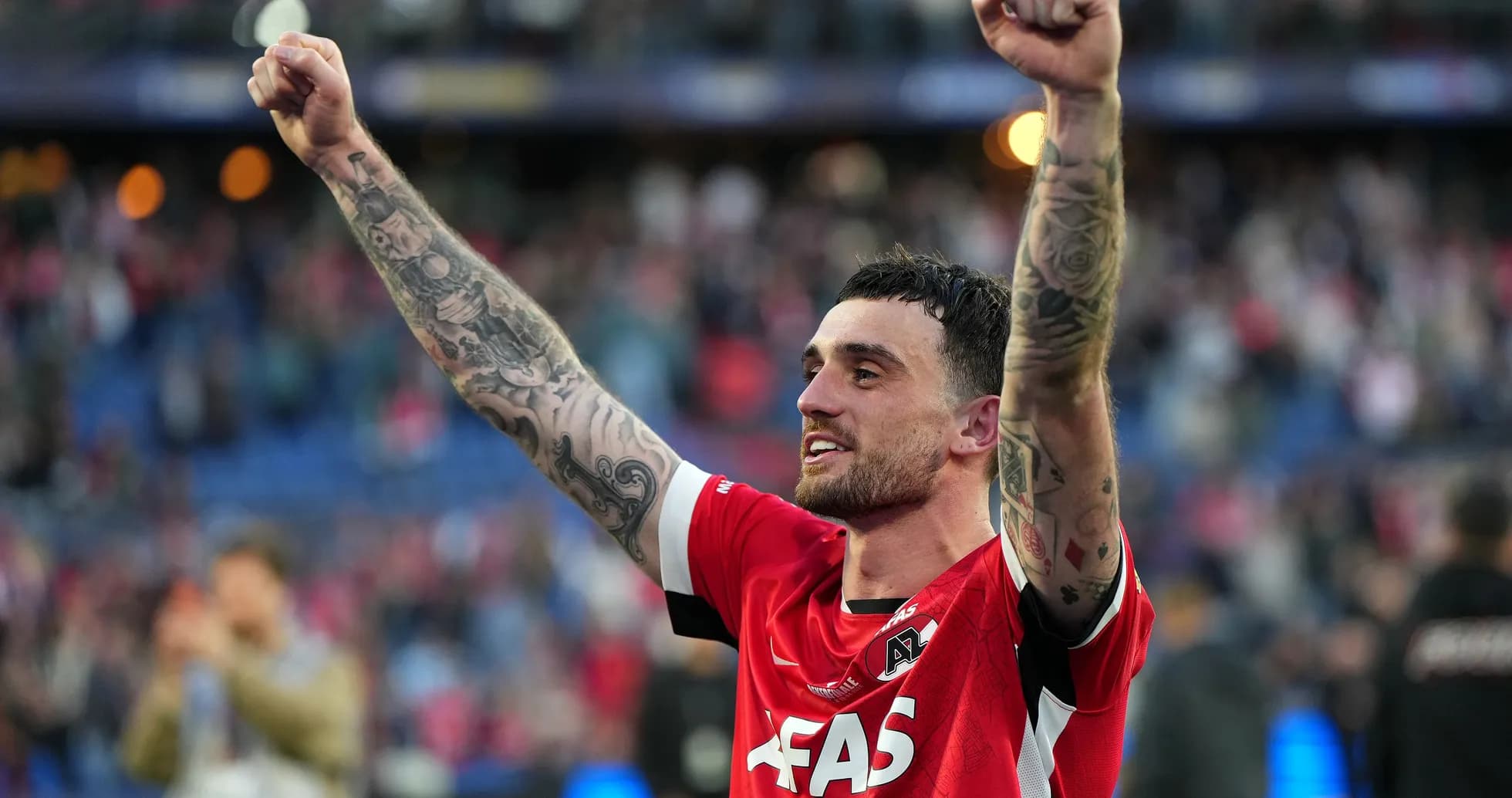 Player celebrating with raised arms in red jersey Player celebrating with raised arms in red jersey