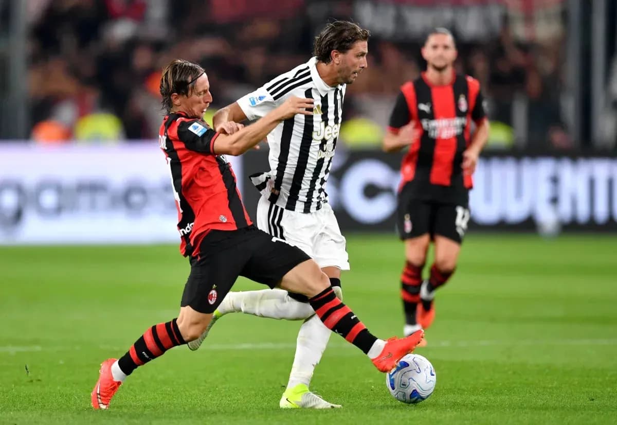 Player from AC Milan tackles Juventus player during match Player from AC Milan tackles Juventus player during match