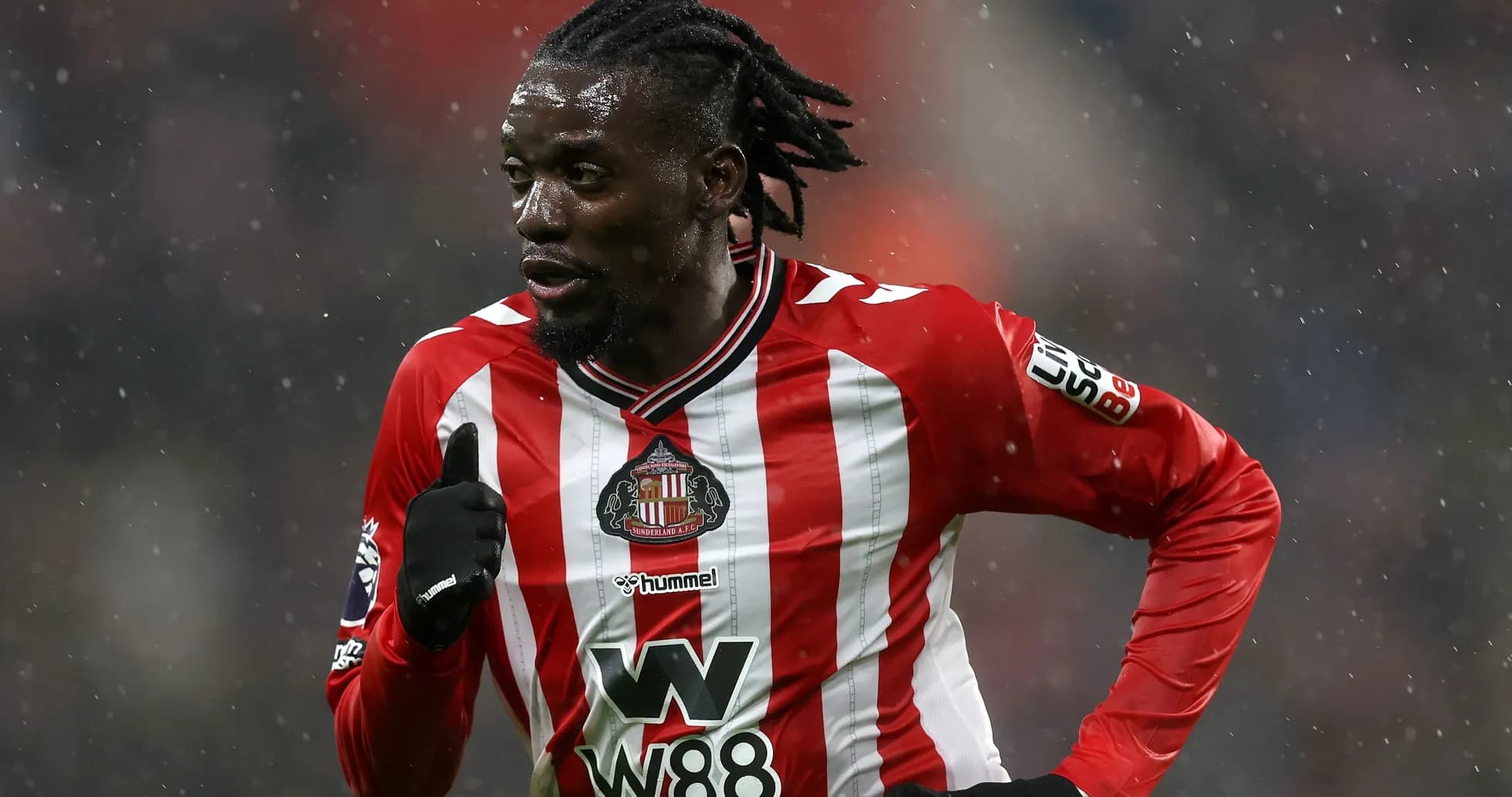 Sunderland player running in rain during match Sunderland player running in rain during match