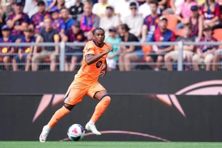 Player in orange kit sprinting on the field Player in orange kit sprinting on the field