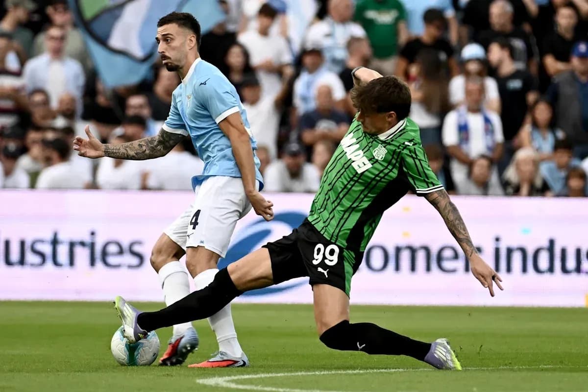 Player from Lazio evading tackle from Sassuolo opponent Player from Lazio evading tackle from Sassuolo opponent