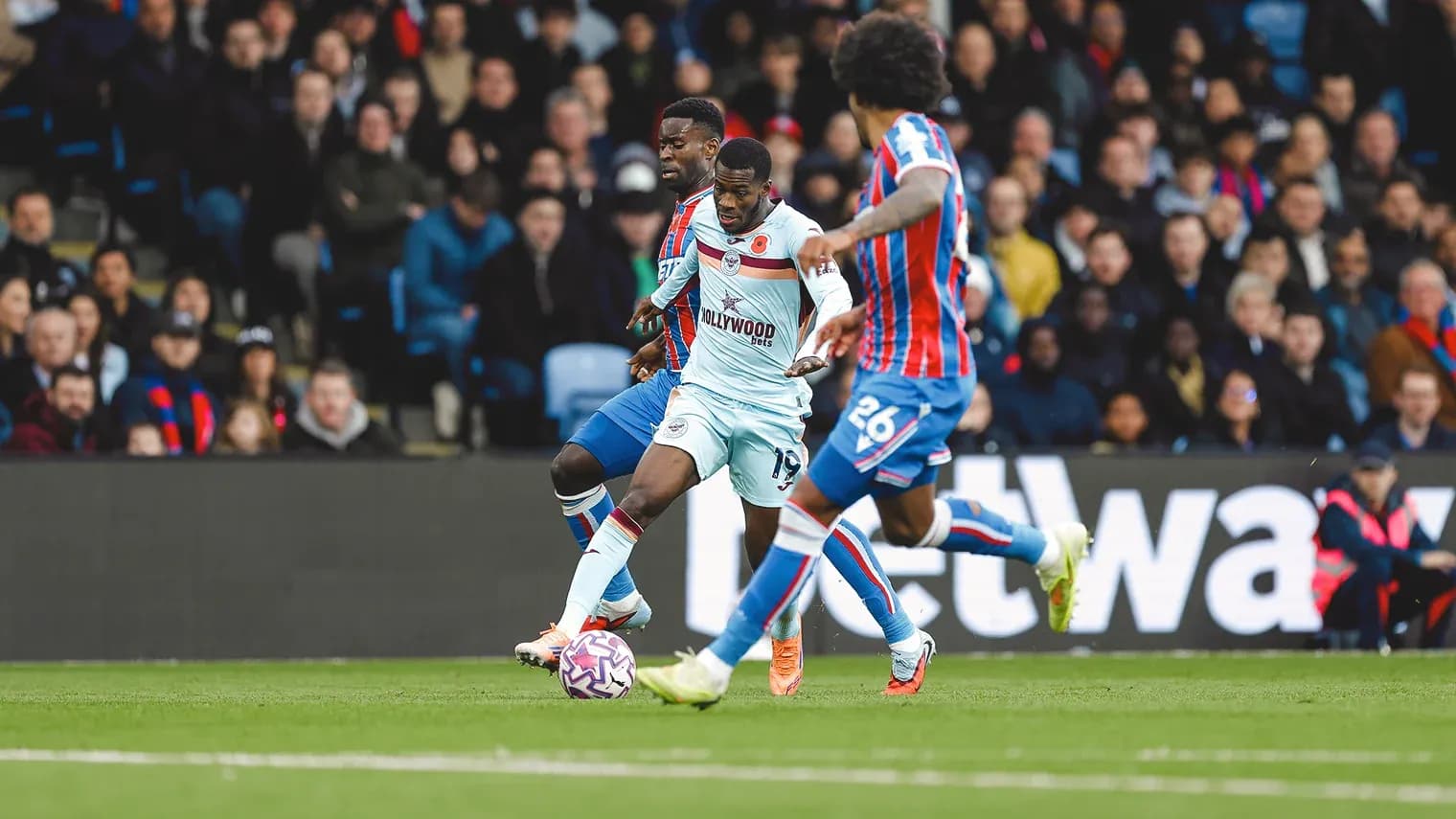 Brentford player dribbling against Crystal Palace defenders Brentford player dribbling against Crystal Palace defenders