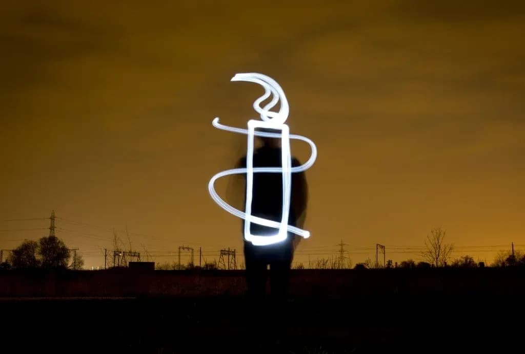 Person creating light drawing in night landscape Person creating light drawing in night landscape