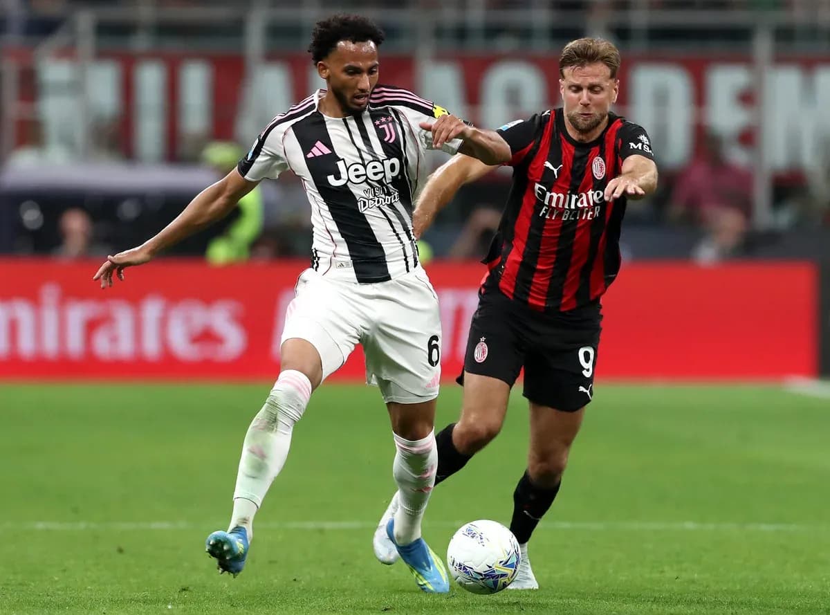 Juventus player challenges AC Milan opponent for the ball Juventus player challenges AC Milan opponent for the ball