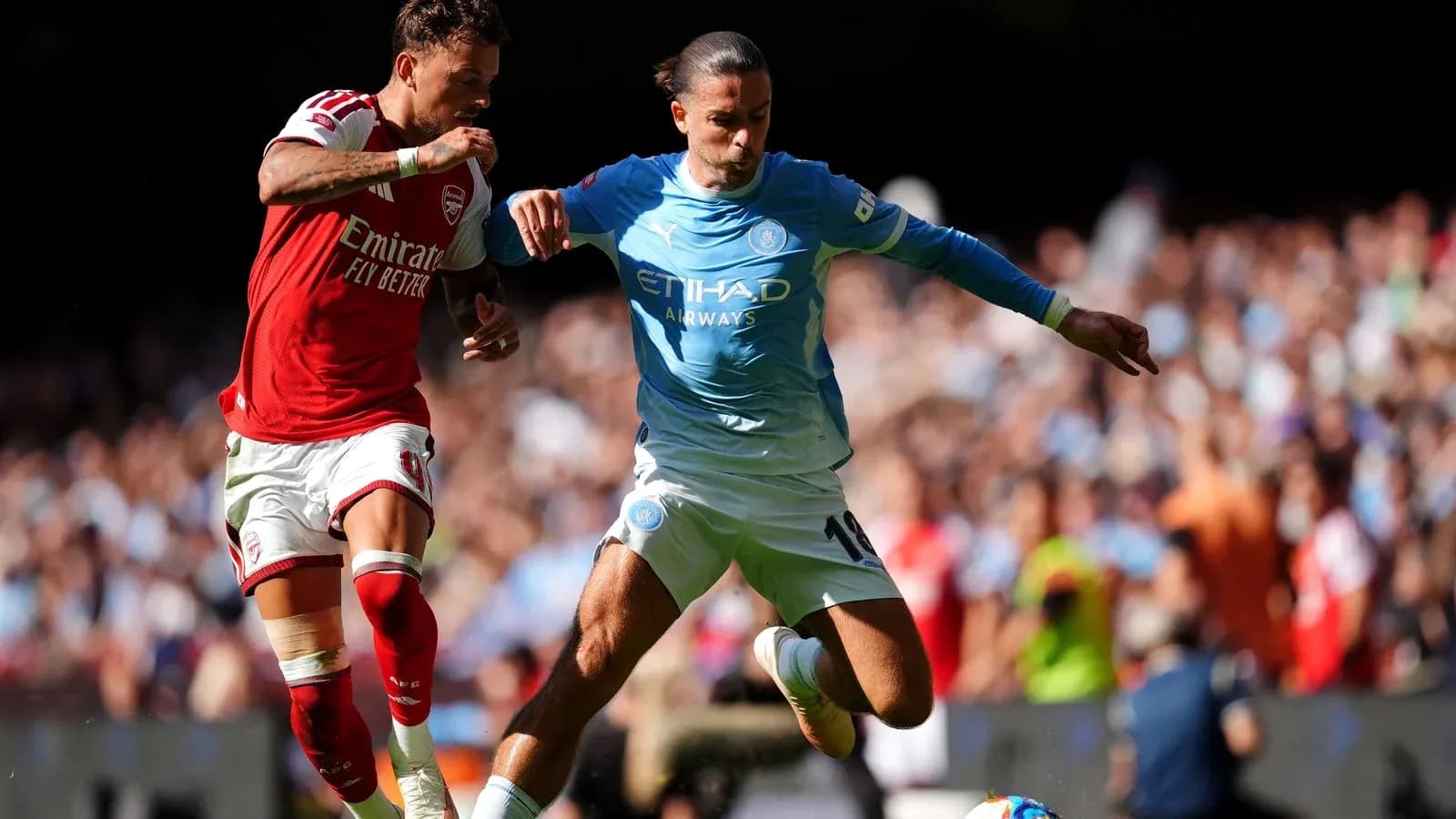 Arsenal and Manchester City players contesting for the ball Arsenal and Manchester City players contesting for the ball