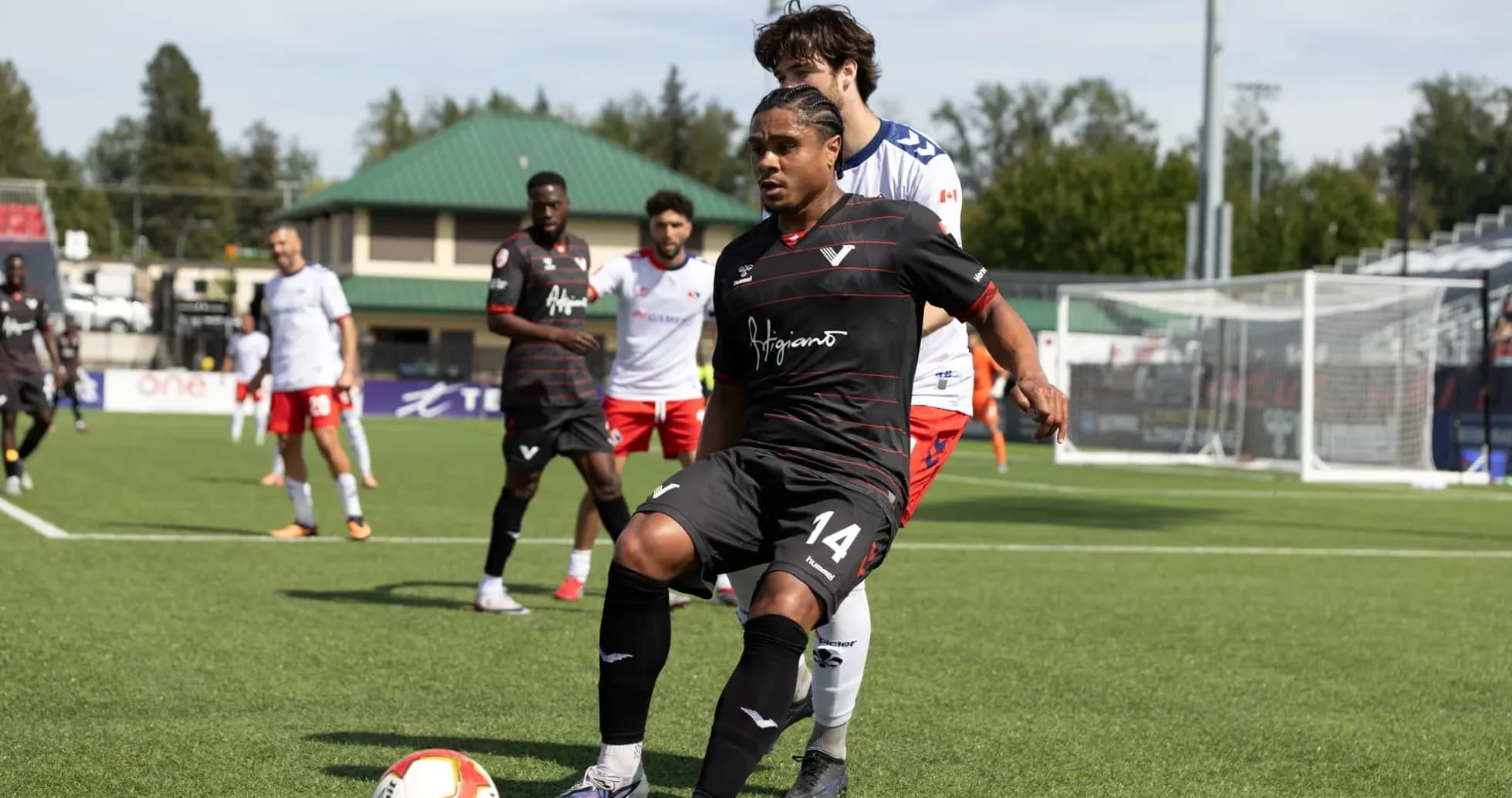 Player in black jersey preparing to pass ball Player in black jersey preparing to pass ball
