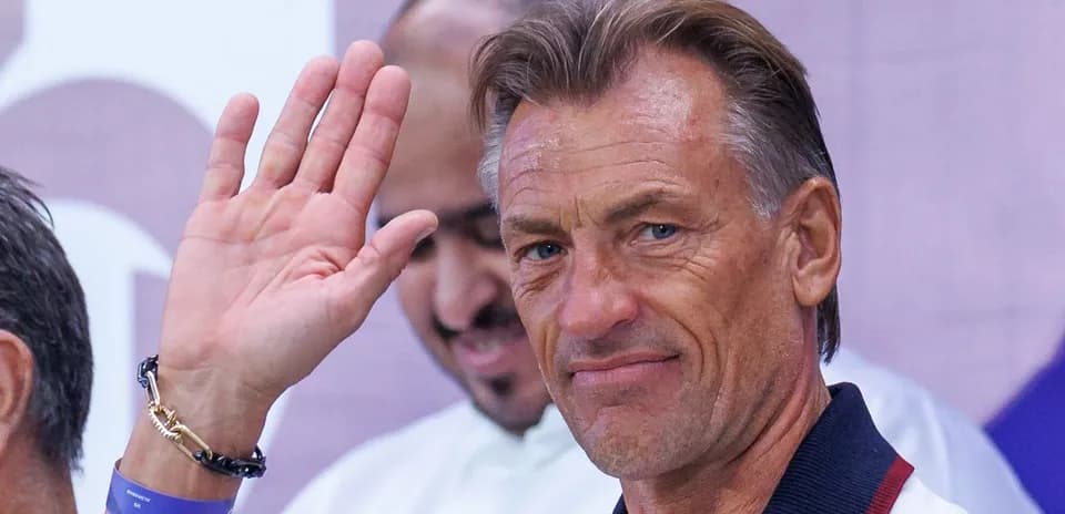 Coach waving during a press event or appearance Coach waving during a press event or appearance