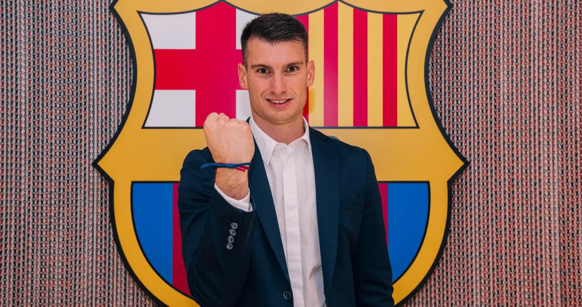 Player posing with clenched fist by Barcelona logo Player posing with clenched fist by Barcelona logo