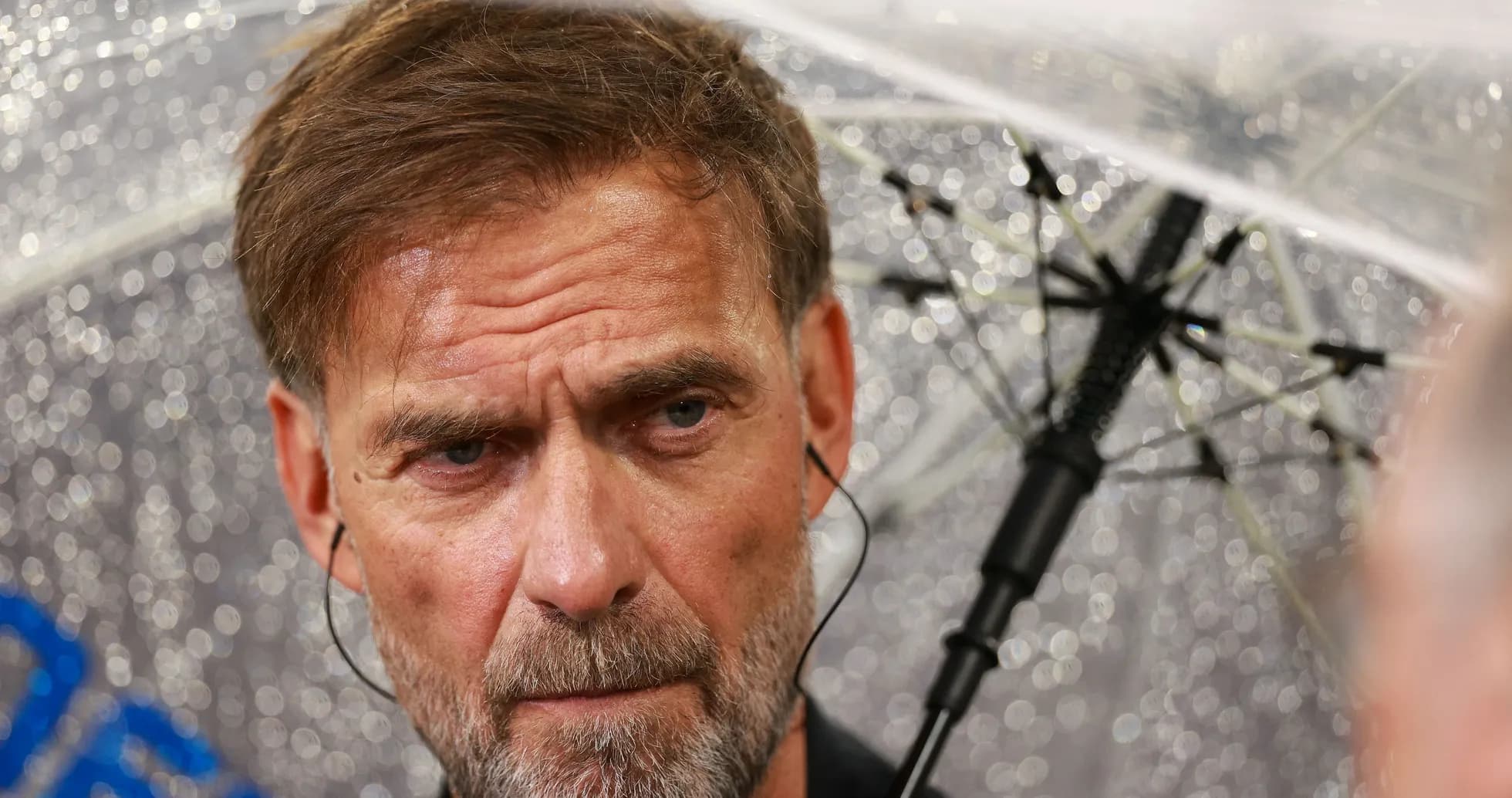 Coach under an umbrella during a press event Coach under an umbrella during a press event