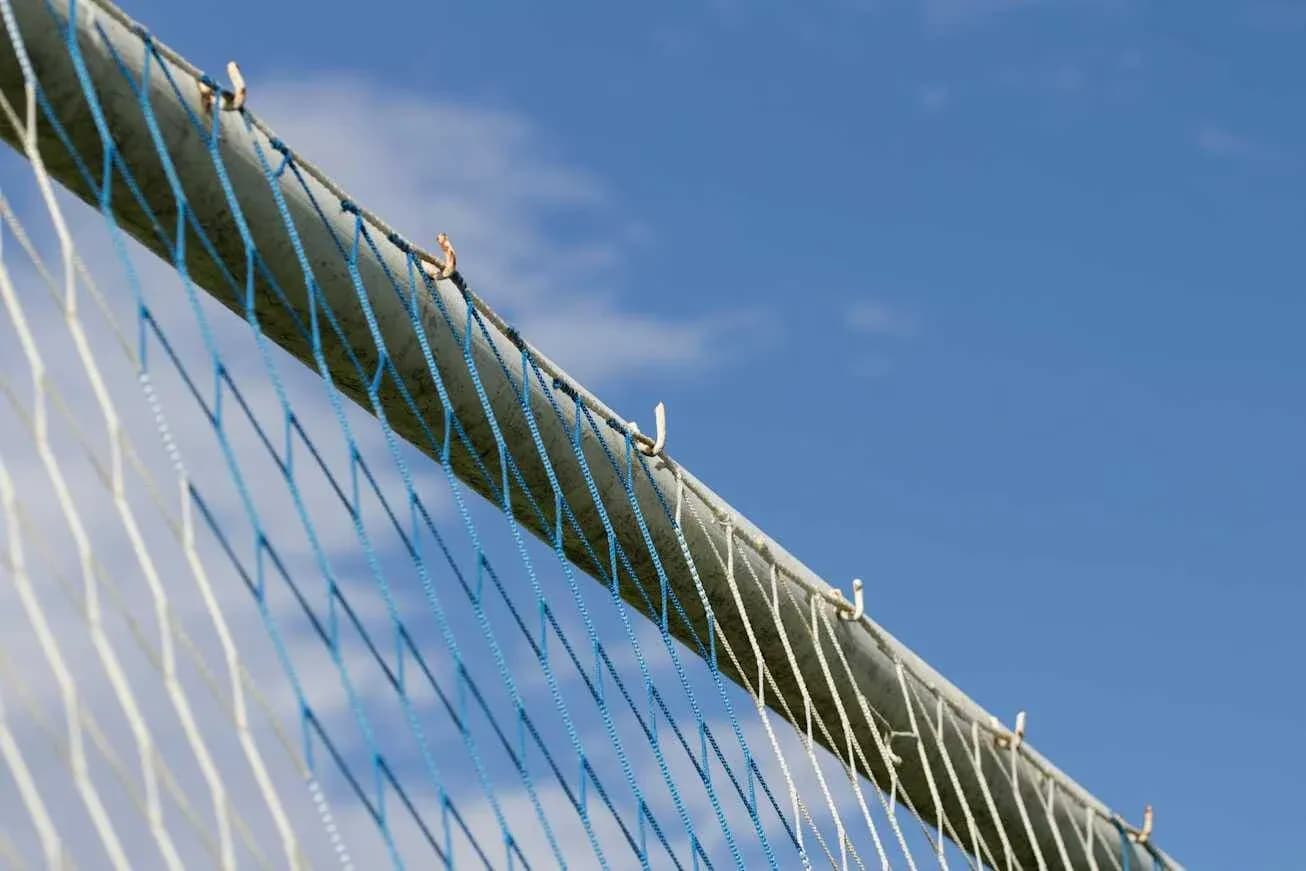 Close-up of a sports goal net against blue sky Close-up of a sports goal net against blue sky