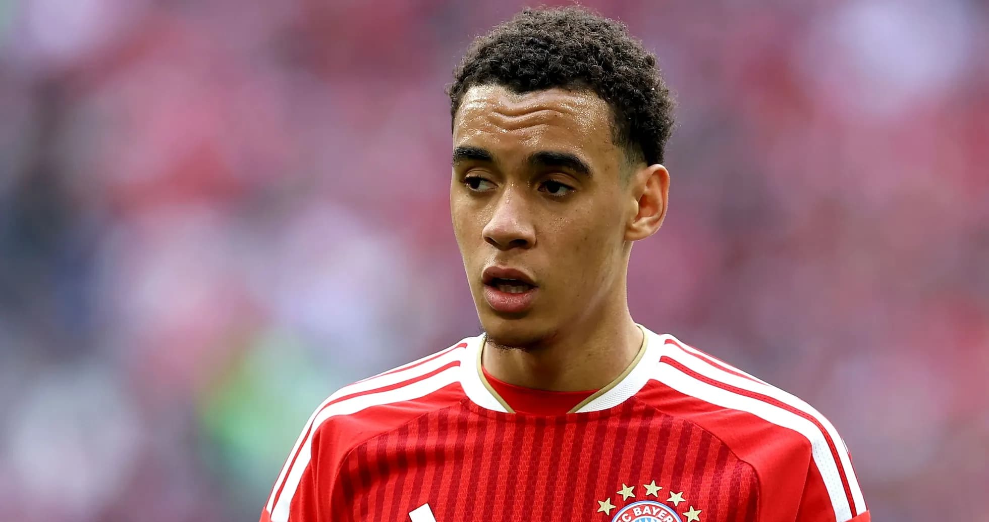 Player in red Bayern Munich jersey on field Player in red Bayern Munich jersey on field