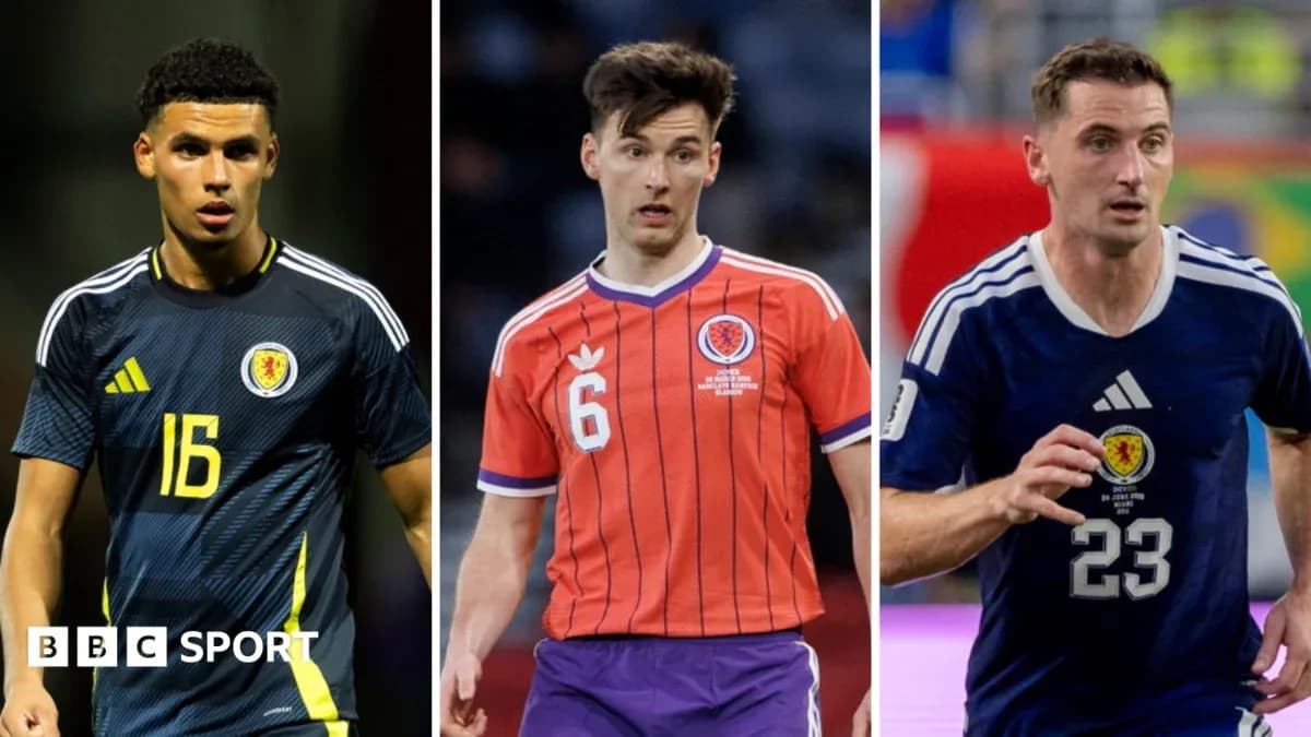 Three Scotland players in football kits during match Three Scotland players in football kits during match