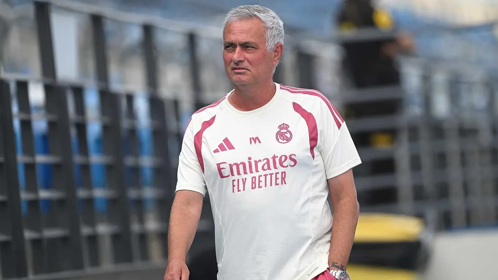 Coach walking on training pitch in team attire Coach walking on training pitch in team attire